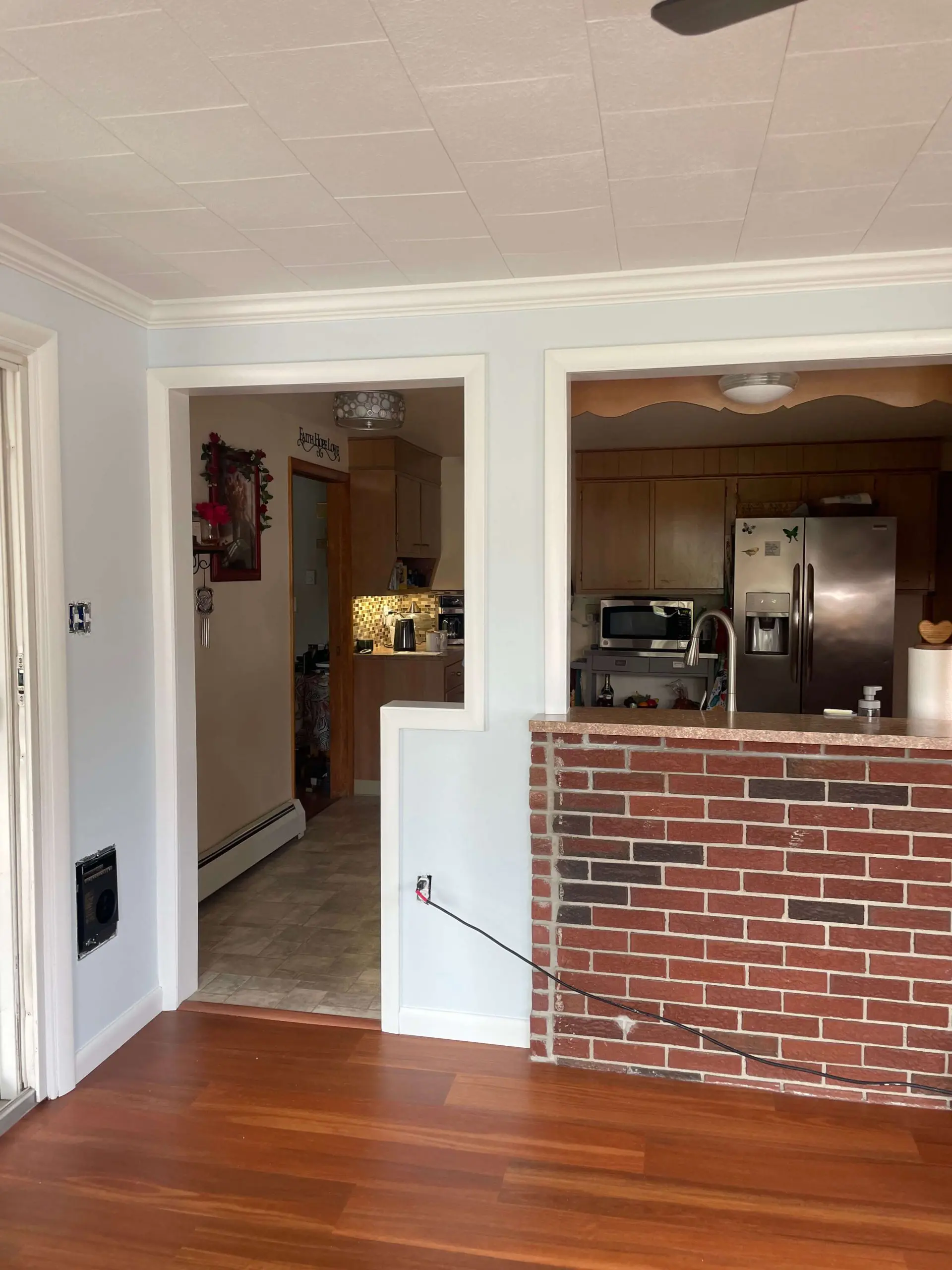 Kitchen remodel featuring a brick breakfast bar and light blue walls updated by Martzall's Custom Surfaces for a modern home interior.