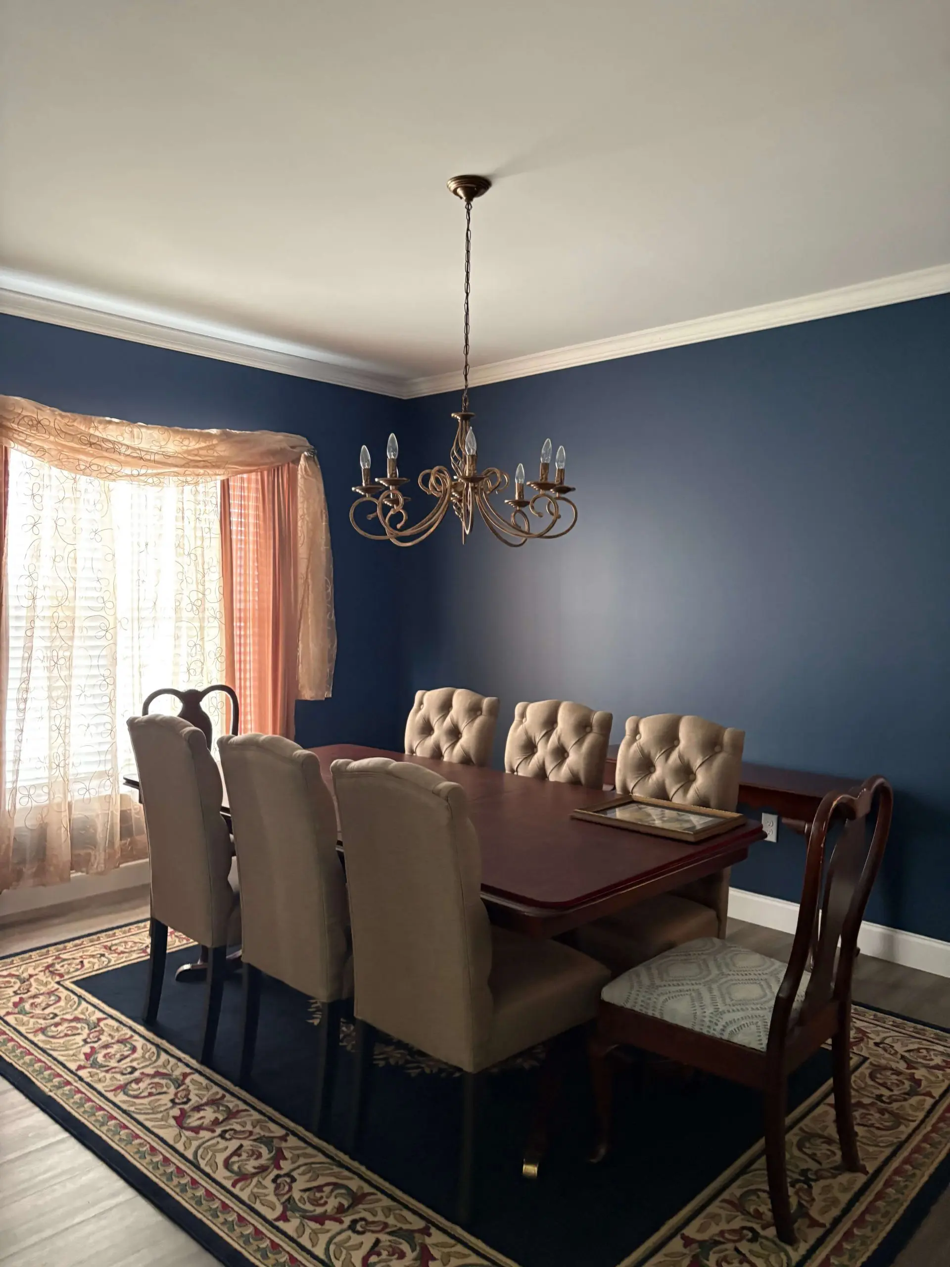 Martzall's Custom Surfaces professionally painted navy blue dining room walls featuring a cherry wood hutch and elegant crown molding.