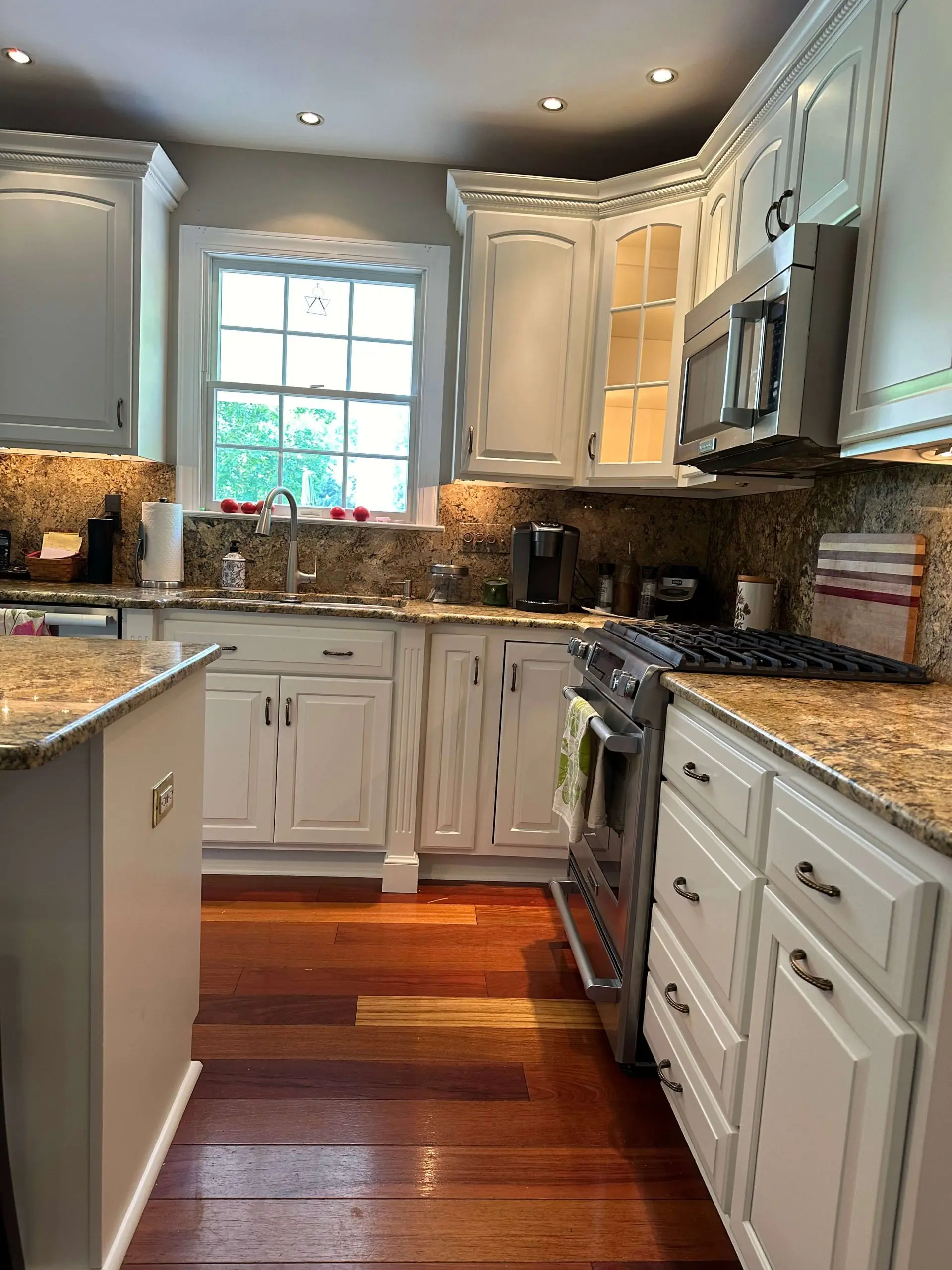 Luxury kitchen interior showcasing matching granite countertops and full-height backsplash by Martzall's Custom Surfaces.