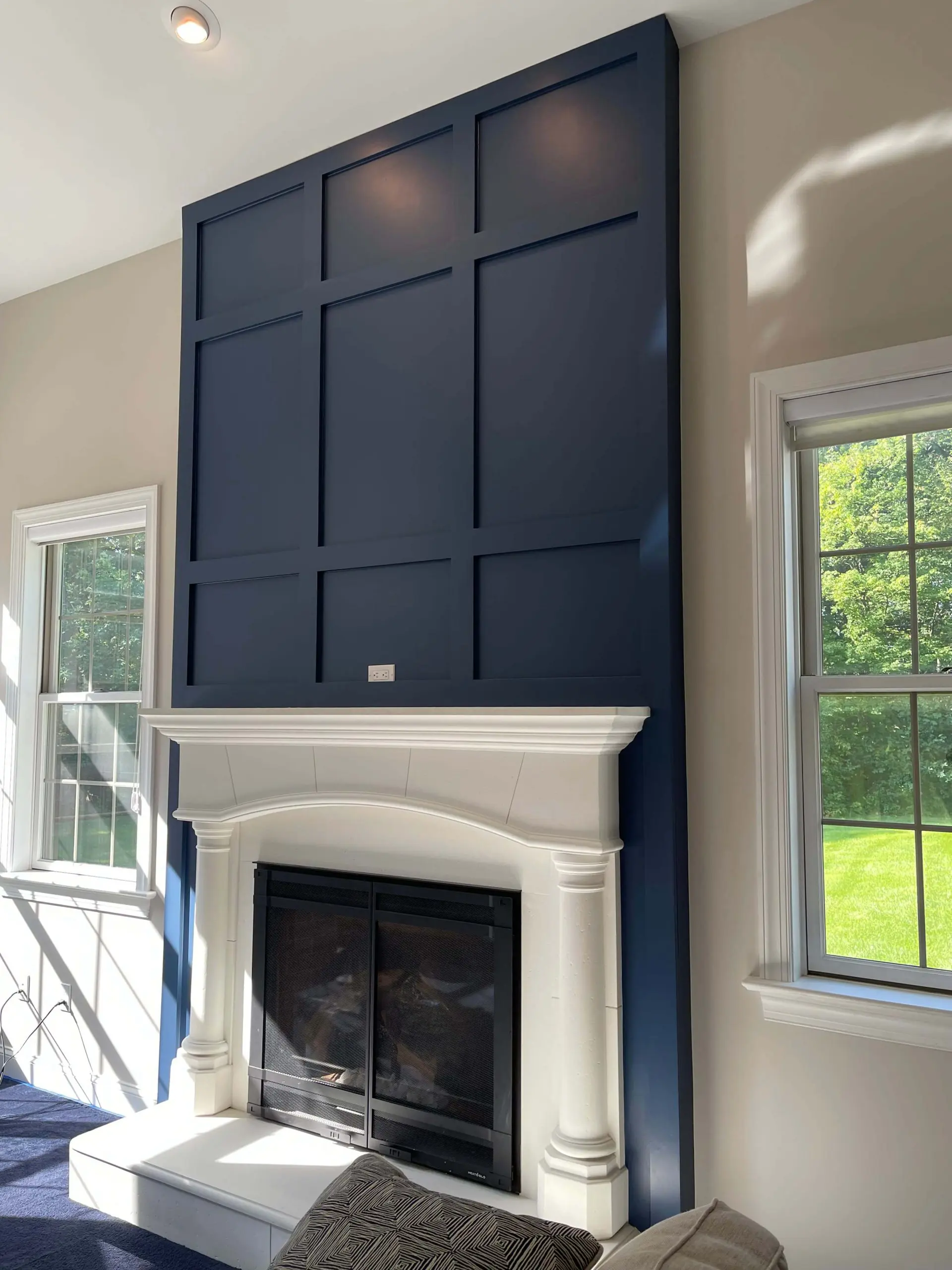blue accent wall with trim design above white fireplace