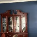 Navy dining room walls and white crown molding completed after a professional interior painting consultation