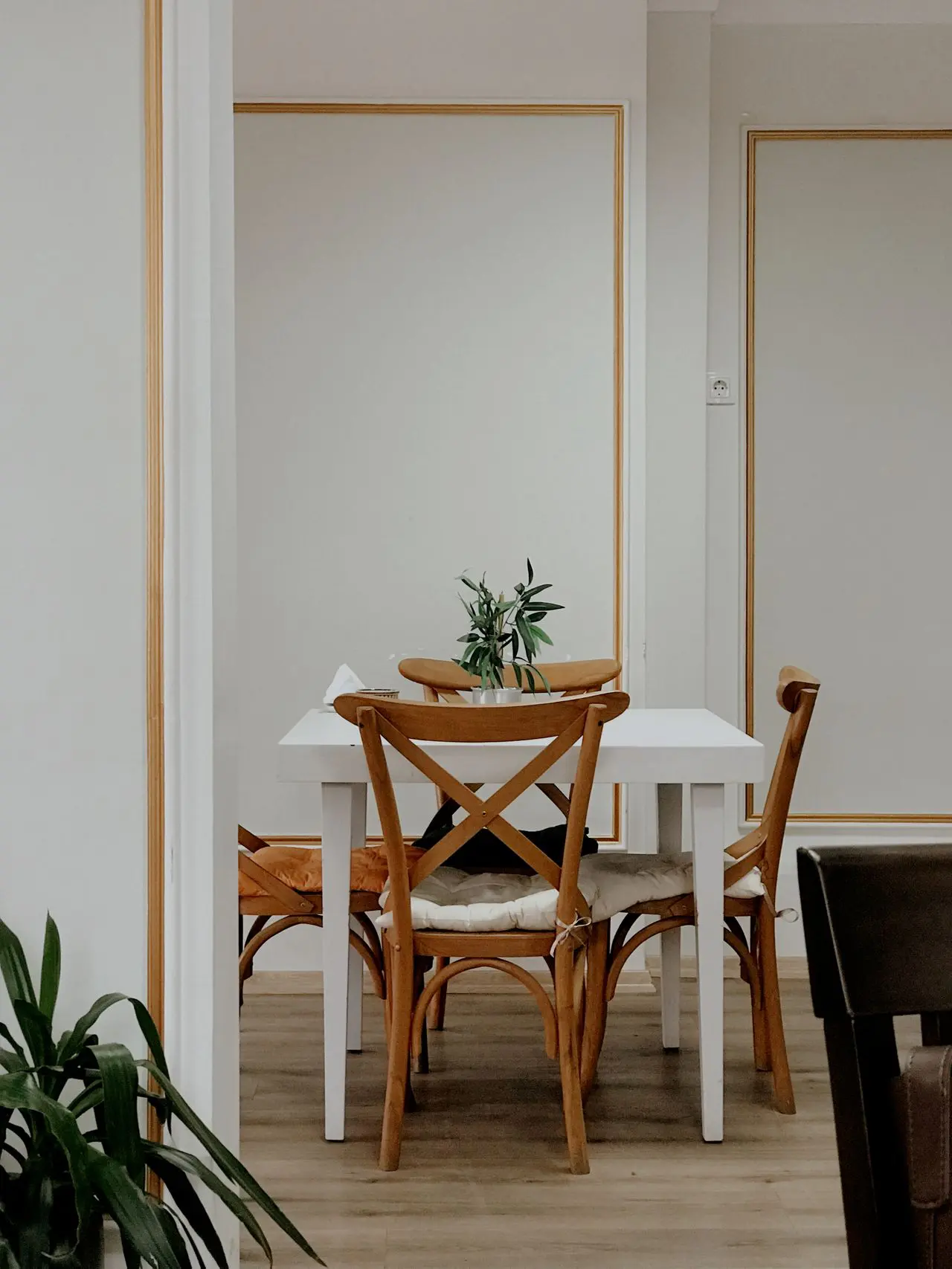 White dining room walls with gold accent moulding finished by professional interior painters in Denver, PA
