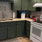Professionally painted sage green kitchen cabinets with white appliances and granite countertops by Martzall's Custom Surfaces in Lancaster County, PA