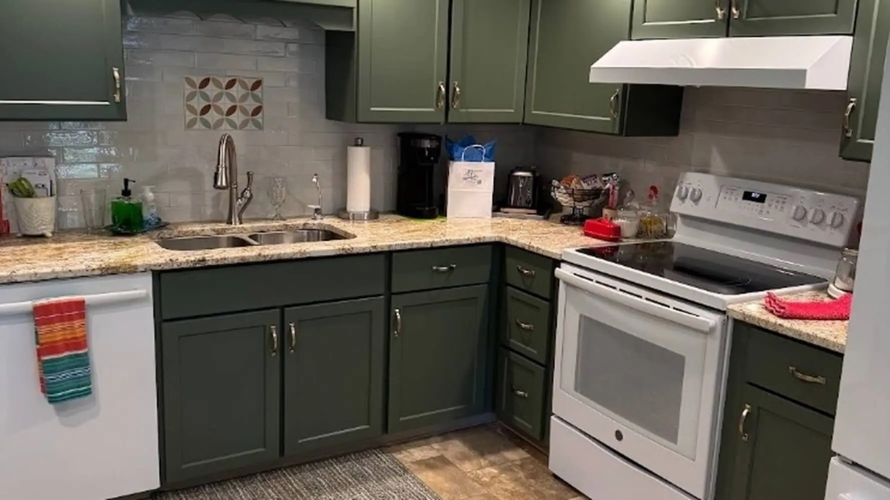 Professionally painted sage green kitchen cabinets with white appliances and granite countertops by Martzall's Custom Surfaces in Lancaster County, PA