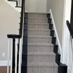 Professionally painted staircase and hallway with taupe walls, white trim, and black railings by Martzall's Custom Surfaces in Lancaster County, PA