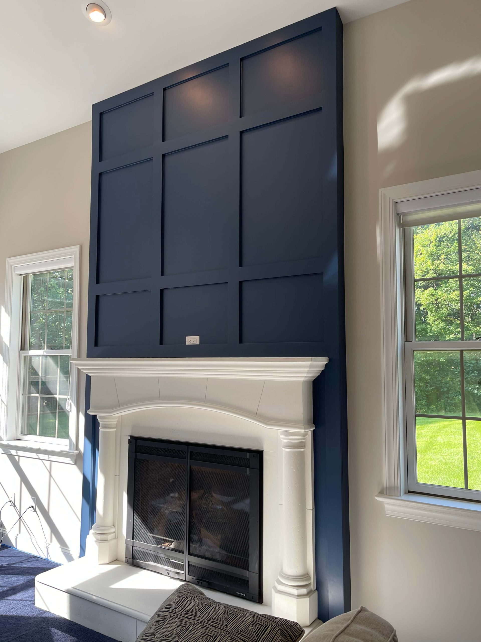 blue accent wall with trim design above white fireplace
