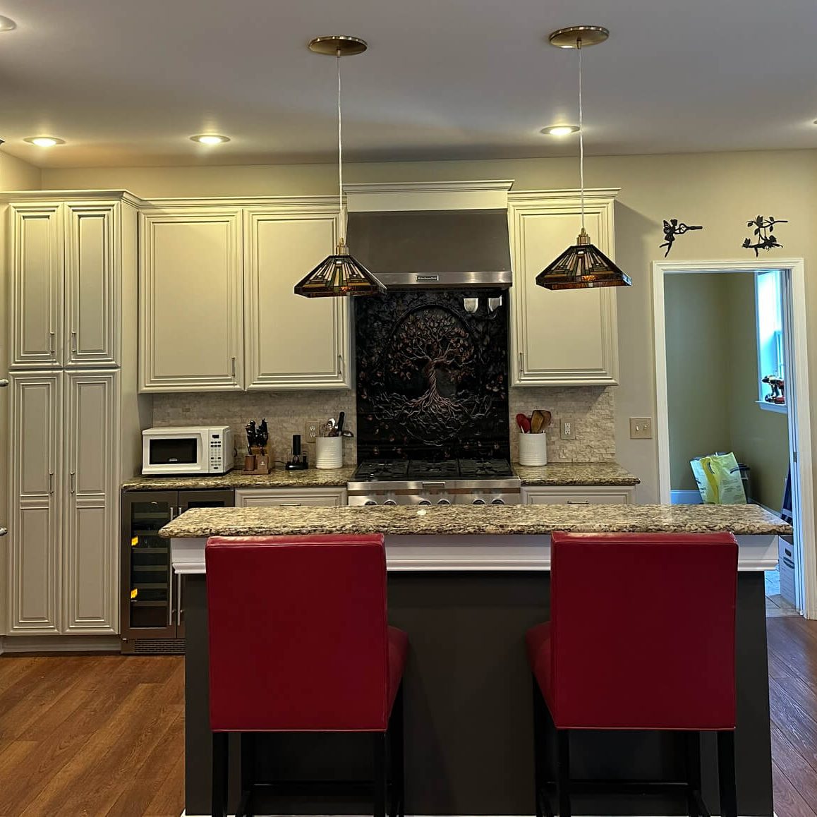 Creamy white kitchen cabinets with granite countertops and island seating painted by Martzall’s Custom Surfaces, serving Lititz, PA and surrounding communities