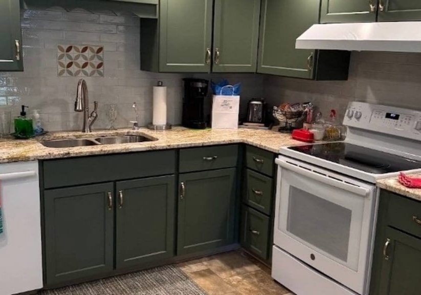 Professionally painted sage green kitchen cabinets with white appliances and granite countertops by Martzall's Custom Surfaces in Lancaster County, PA