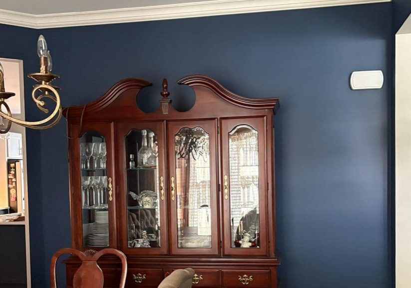 Navy dining room walls and white crown molding completed after a professional interior painting consultation